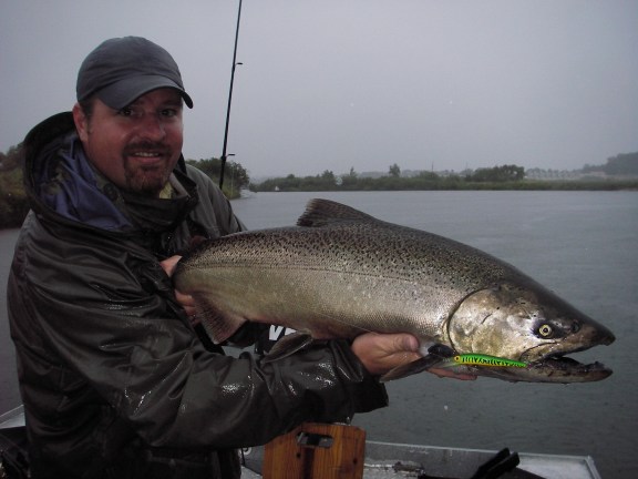 Jay Koehler holds up a rainy day chinook salmon caught on the Manistee River. Photo by Howard Meyerson