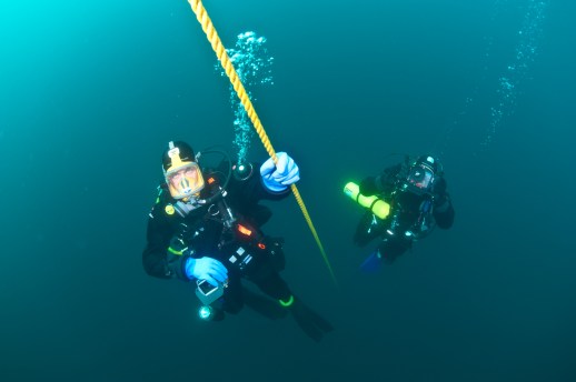 Divers John Achterhoff and John Hanson ascend a mooring line at the end of a dive. Photo: Paul Chase