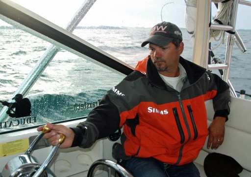 Captain Brian Butts pilots his  boat through bouncing seas hunting for big salmon on Lake Michigan. Photo: Howard Meyerson