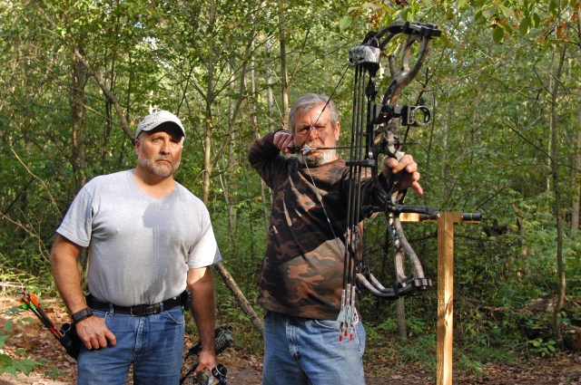 Mike Niva (left) looks over Mike Kotecki's shoulder as he practices for the opening of archery deer season and draws a bead on a 3-D target at the Fruitport Conservation Club. Photo: Howard Meyerson