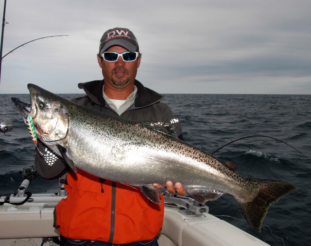 Captain Brian Butts, owner of Sea Flea Charters out of Grand Haven, MI, holds up one of the large chinook salmon caught on a summer outing in 2013. Photo: Howard Meyerson