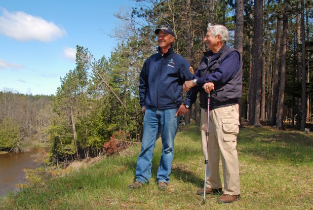 Dick Naperala (left) and Dick Tomorsky enjoy a view of the Manistee River from elevated bluff along the a new portion of the North Country National Scenic Trail near Fife Lake. Photo: Howard Meyerson.