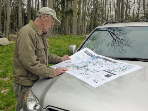 Volunteer trail builder and coordinator, Arlen Matson, looks over the map of the new trail that was soon to be posted at the U.S. 131 roadside park kiosk. Photo: Howard Meyerson.