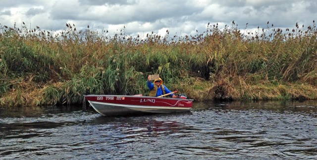 Cliff Minton holds up a sign telling friends he is making his 1000th fishing trip on the Lower White River. Photo: Photo Bill Bishop.