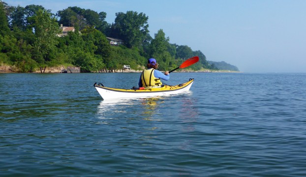 A paddler enjoys exploring the sandy Lake Michigan shoreline by kayak, part of what will become the Lake Michigan Water Trail. Photo: Howard Meyerson. 