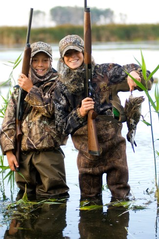A young hunter holds up a green-winged teal, a species that sticks around longer than blue-wings. Photo: Dave Kenyon, Michigan DNR. 