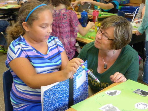 Teacher Laura Mitchell, discusses the food web with eight year old Janae Fisher, a third grade student at Reeths Puffer Elementary.