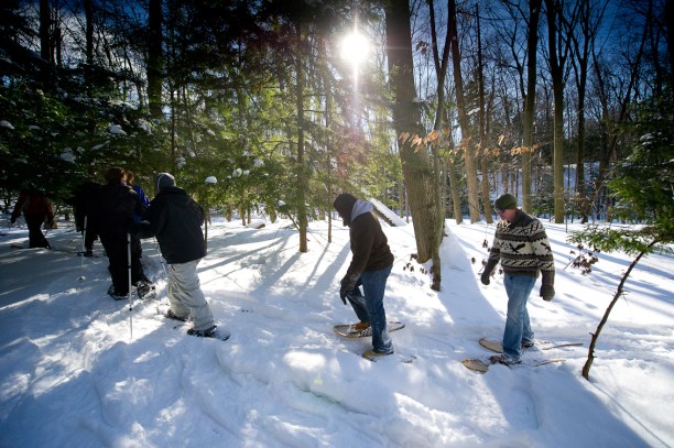 A group enjoys a guided snowshoe hike at P.J. Hoffmaster State Park where wooden snowshoes can be rented. Photo credit: Dave Kenyon, Michigan DNR