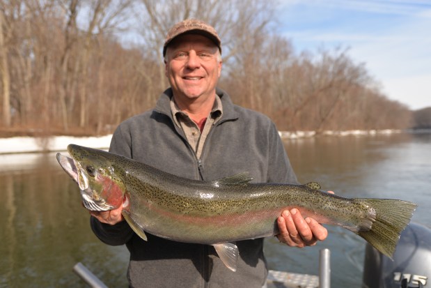 Captain Russ Clark holds up a nice steelhead landed on the St. Joseph River in late January. Photo: Howard Meyerson