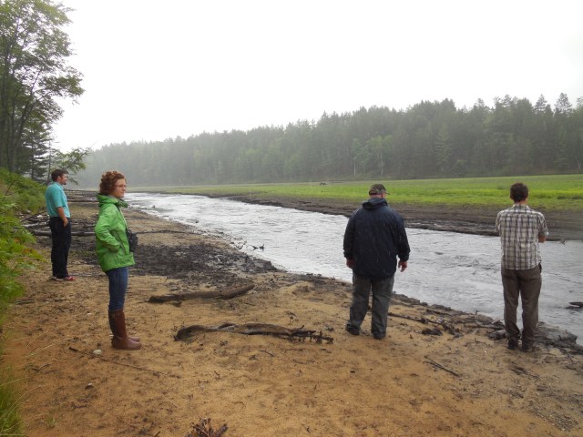 HP staff walking about halfway in old impoundment
